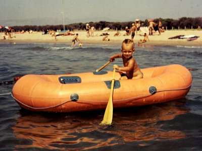 Ich als Kind in einem orangen Gummiboot